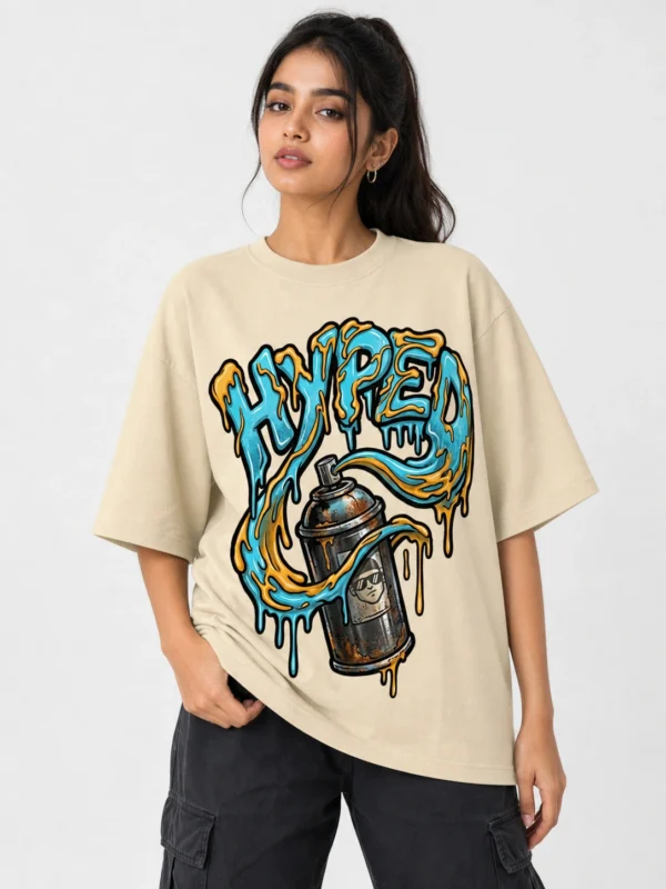 Hyped oversized beige printed graffiti graphic t-shirt for women with blue orange spray can drip art design - streetwear fashion girls - Voux.in