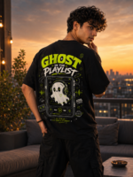 Young woman wearing VOUX black oversized cotton t-shirt with neon green Ghost in the Playlist graphic print on the back, featuring a cute ghost with headphones on a retro music player, styled in streetwear aesthetic against a city sunset backdrop